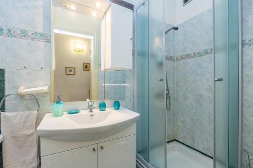 a bathroom with a sink and a shower at Apartment Juna in Rijeka
