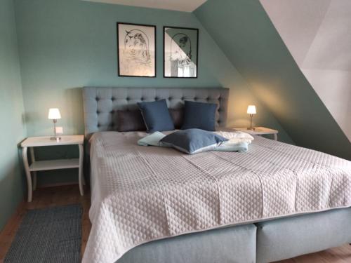 - une chambre avec un lit doté d'oreillers bleus et de 2 lampes dans l'établissement Ferienhaus Blaue Blume mit 11 kW Ladestation, Kamin, Terrasse, eingezäuntem Garten, Sauna, WLAN, Netflix, 2 Hunde willkommen!, à Güntersberge