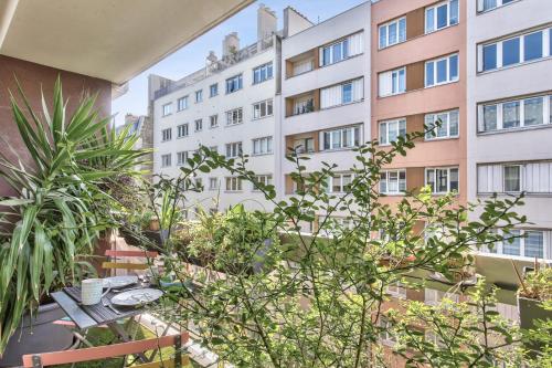 - un balcon avec une table et un bâtiment dans l'établissement Appartement Charlys avec sa terrasse - Welkeys, à Paris