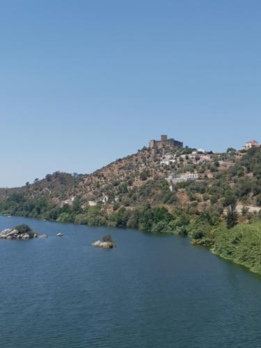 a view of a lake with a hill in the background at Monte das Flores Casa de Campo in Torre Fundeira