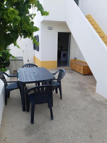 a black table and chairs on a patio at Monte das Flores Casa de Campo 