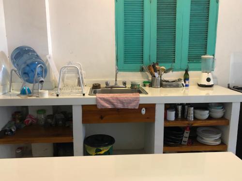 a kitchen counter with a sink and green shutters at casa kashiikaii in Palomino