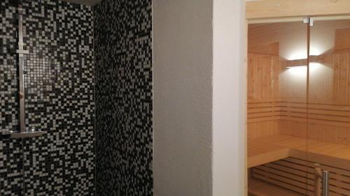 eine ebenerdige Dusche im Bad mit schwarzen und weißen Fliesen in der Unterkunft Villa Katzenbuckel in Waldbrunn