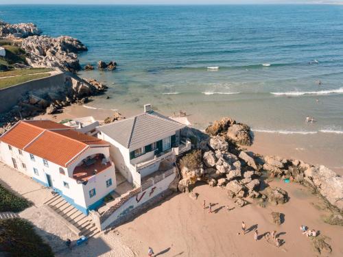 a house on a beach next to the ocean at Casa da Rocha in Baleal
