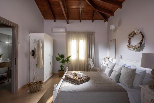 um quarto com uma cama com almofadas brancas em Filothei Beach House with pool em Kalamaki