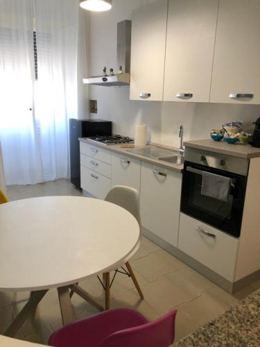 a kitchen with a white table and a table and a table and chairs at Casa Kippis - Rifinito appartamento con posto auto in Taranto