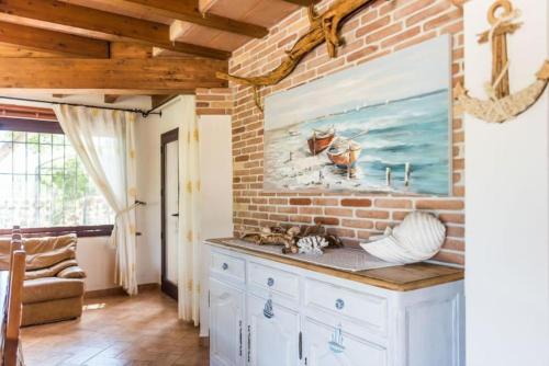 a kitchen with a brick wall and a counter at villa con immenso giardino in Orosei