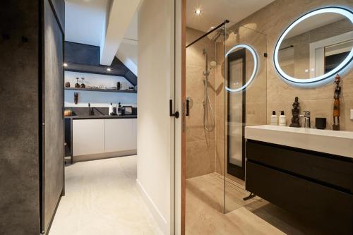 a bathroom with a shower and a sink and a mirror at Nomad Water Studio in Harderwijk