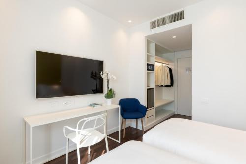 a bedroom with a desk with a tv and two chairs at Hotel Morfeo in Milan