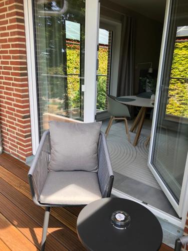 a chair sitting on a porch with a table at Gästehaus Muhl in Strukkamp auf Fehmarn