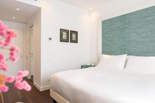 a bedroom with a large white bed with pink accents at Hotel Morfeo in Milan