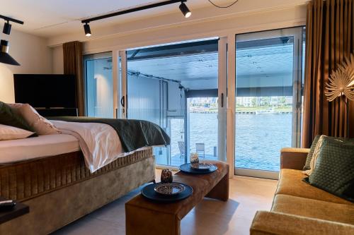 Schlafzimmer mit einem Bett und Blick auf das Wasser in der Unterkunft Nomad Water Studio in Harderwijk