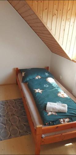 a bed in a room with a wooden bed frame at Kéktúrás-Tóra Nyíló privát bérlemény in Badacsonytomaj