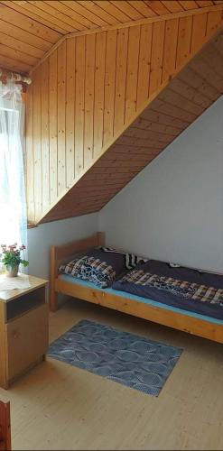 a bedroom with a bunk bed in a wooden ceiling at Kéktúrás-Tóra Nyíló privát bérlemény in Badacsonytomaj
