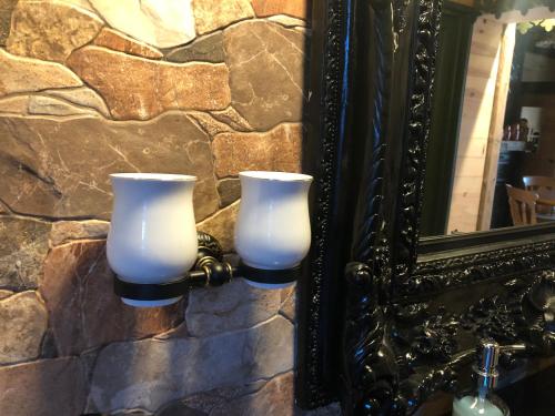 two white candles on a wall next to a mirror at SPA La Casa Blue in Wingles