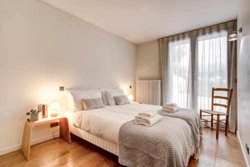 1 dormitorio blanco con 1 cama grande y 1 silla en Chalet Safari. Face au Mont-Blanc. en Chamonix-Mont-Blanc