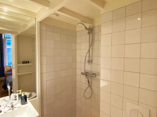 La salle de bains est pourvue d'une douche et d'un lavabo. dans l'établissement Canal Hideaway, à Amsterdam