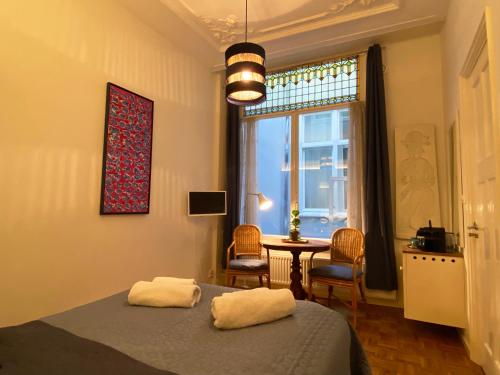 a bedroom with a bed and a table and a window at Canal Hideaway in Amsterdam