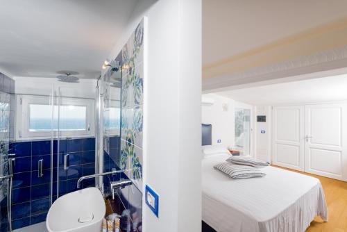 a white bedroom with a blue tiled wall at La Vecchia Portineria in Cetara