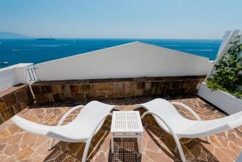 two chairs and a table on a balcony with the ocean at La Vecchia Portineria in Cetara