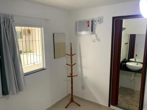 a white bathroom with a sink and a mirror at Aloha Beach Temporada in Cabo Frio