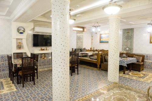 a restaurant with columns and a dining room with tables at Durdona Guest House in Samarkand