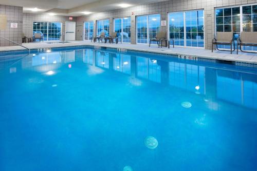 a swimming pool with blue water in a building at Candlewood Suites Harrisburg I-81 Hershey Area, an IHG Hotel in Harrisburg