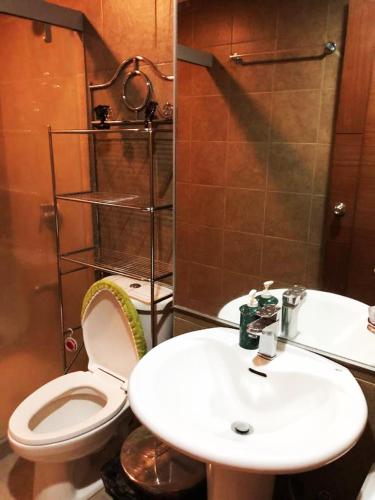 a bathroom with a white toilet and a sink at Splendido Tagaytay Taal Lake Staycation Free Parking Netflix No Free Pool in Tagaytay