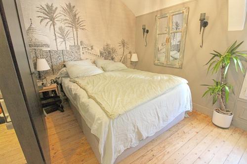 a bedroom with a bed and two potted plants at le cocon de la Bouille in La Bouille