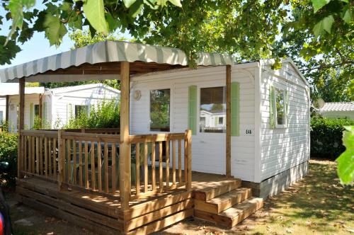 a small white house with a gazebo at Camping Le Beaulieu in Puilboreau