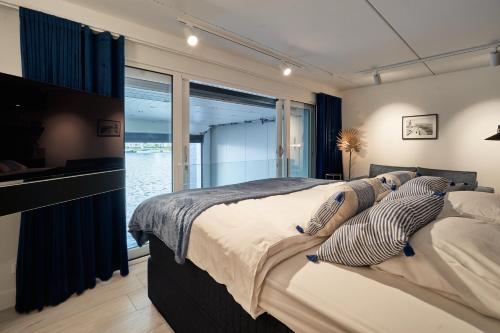 a bedroom with a large bed and a large window at Captains Boathouse Studio in Harderwijk