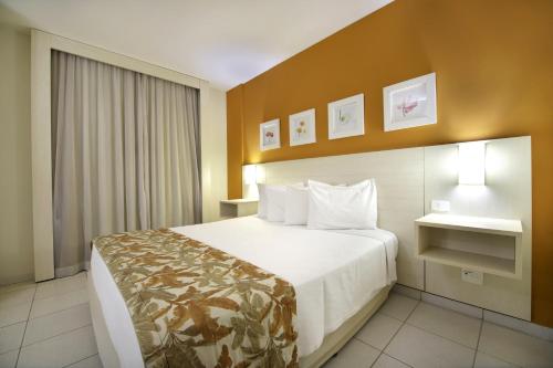 Nobile Inn Executive Ribeirao Preto في ريبيراو بريتو: غرفة فندقية بسرير كبير ونافذة