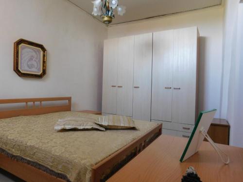 1 dormitorio con cama, armarios blancos y espejo en Casa Vacanze "Za N'Zina", en Dattilo