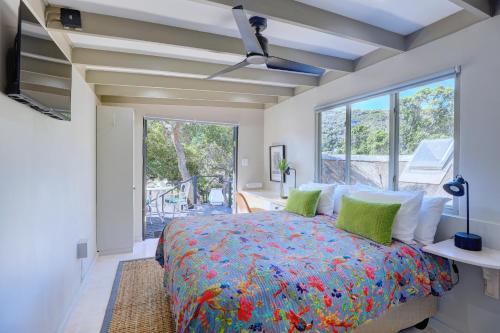a bedroom with a bed and a large window at Moontide Riverside Lodge in Wilderness