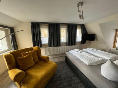 ein Schlafzimmer mit einem Bett, einem Sofa und Fenstern in der Unterkunft Ferienhaus Wiethüchter in Lübeck