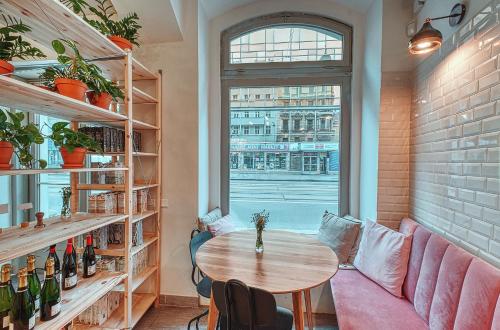 Zimmer mit einem Tisch, einem Sofa und einem Fenster in der Unterkunft Salvator Superior Apartments in Prag