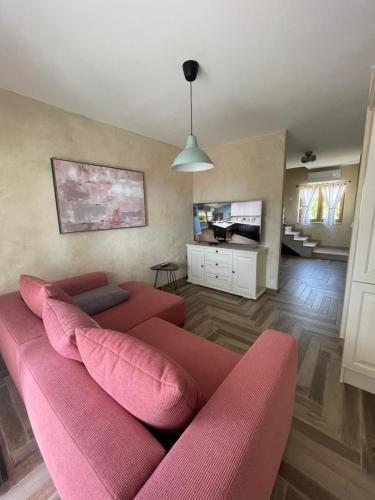 ein Wohnzimmer mit einem roten Sofa und einem TV in der Unterkunft Apartments Sanja in Krk