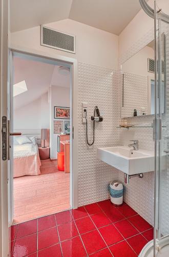 a bathroom with a sink and a red tile floor at Salvator Boutique Hotel vegan-friendly in Prague