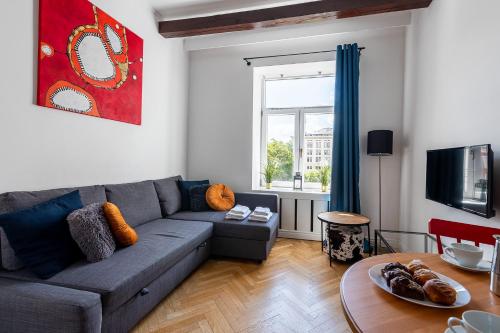 een woonkamer met een bank en een tafel bij Wspólna 54A - Red - Good Apartments in Warschau