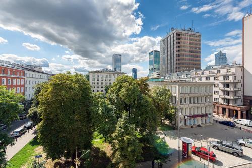 uitzicht op een stad met bomen en gebouwen bij Wspólna 54A - Red - Good Apartments in Warschau