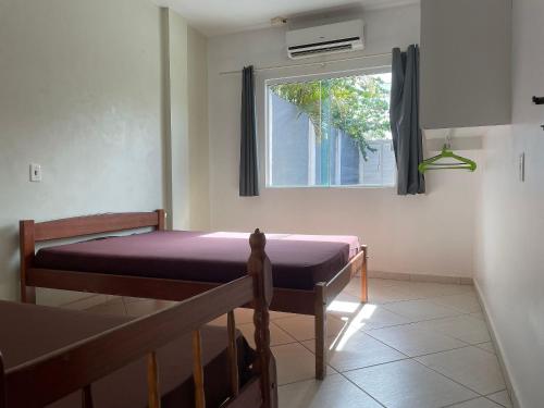 - une chambre avec 2 lits et une fenêtre dans l'établissement Casa com piscina Balneario Ipanema PR, à Pontal do Paraná