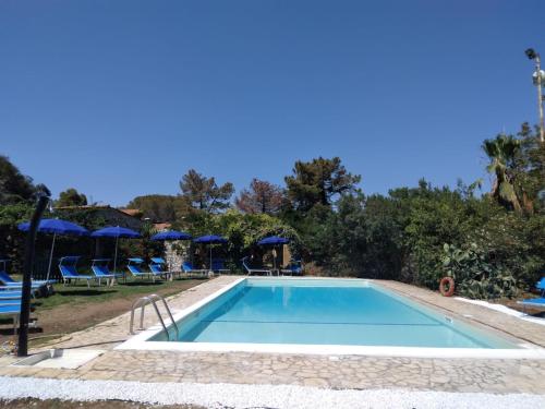 einen Pool in einem Resort mit Stühlen und Sonnenschirmen in der Unterkunft Allegroitalia Elba Golf in Portoferraio