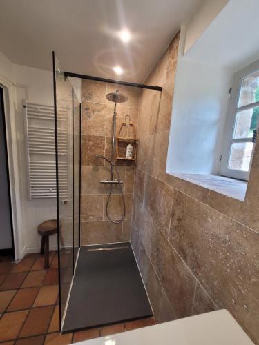 een douche met een glazen deur in de badkamer bij Villa La Cayrouse Piscine Tennis Boulodrome in Le Bouyssou