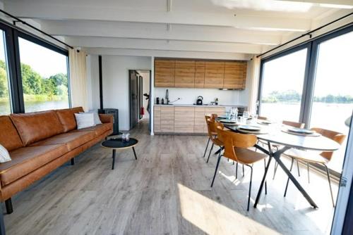 a living room with a couch and a table with chairs at Surla houseboat "Aqua Zen" Kagerplassen with tender in Kaag
