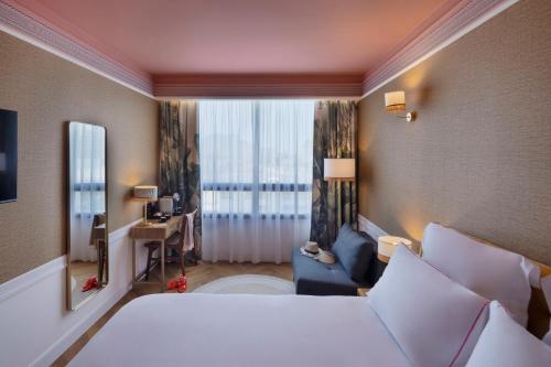 una camera d'albergo con letto e finestra di Brown Eilat a member of Brown Hotels a Eilat