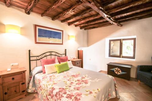 a bedroom with a bed and a couch in a room at Can Jaume Guillem in Sant Carles de Peralta