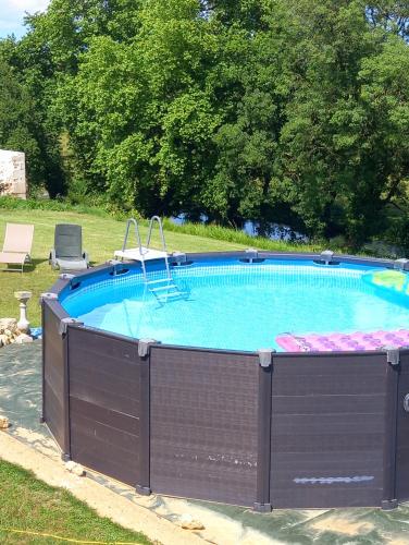 a large swimming pool with a wooden fence around it at Domaine de Seugnac in Pons