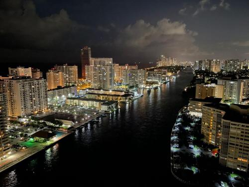 a view of a city at night with a river at Beachy Vibes Studio, 2 Full Beds, Near Everything -30B in Hallandale Beach