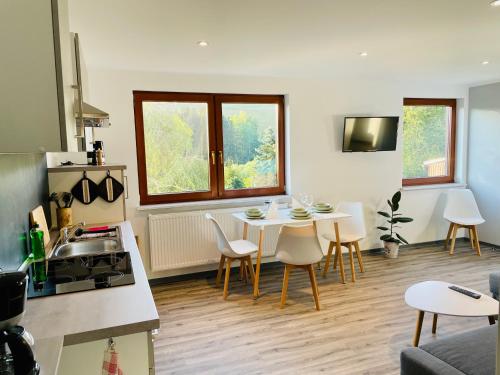uma cozinha e sala de estar com mesa e cadeiras em FeWo - Bergblick em Klingenthal