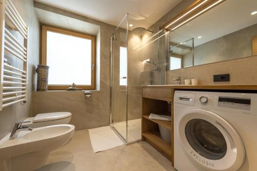 a bathroom with a washing machine and a sink at Apartment Fina in Ortisei